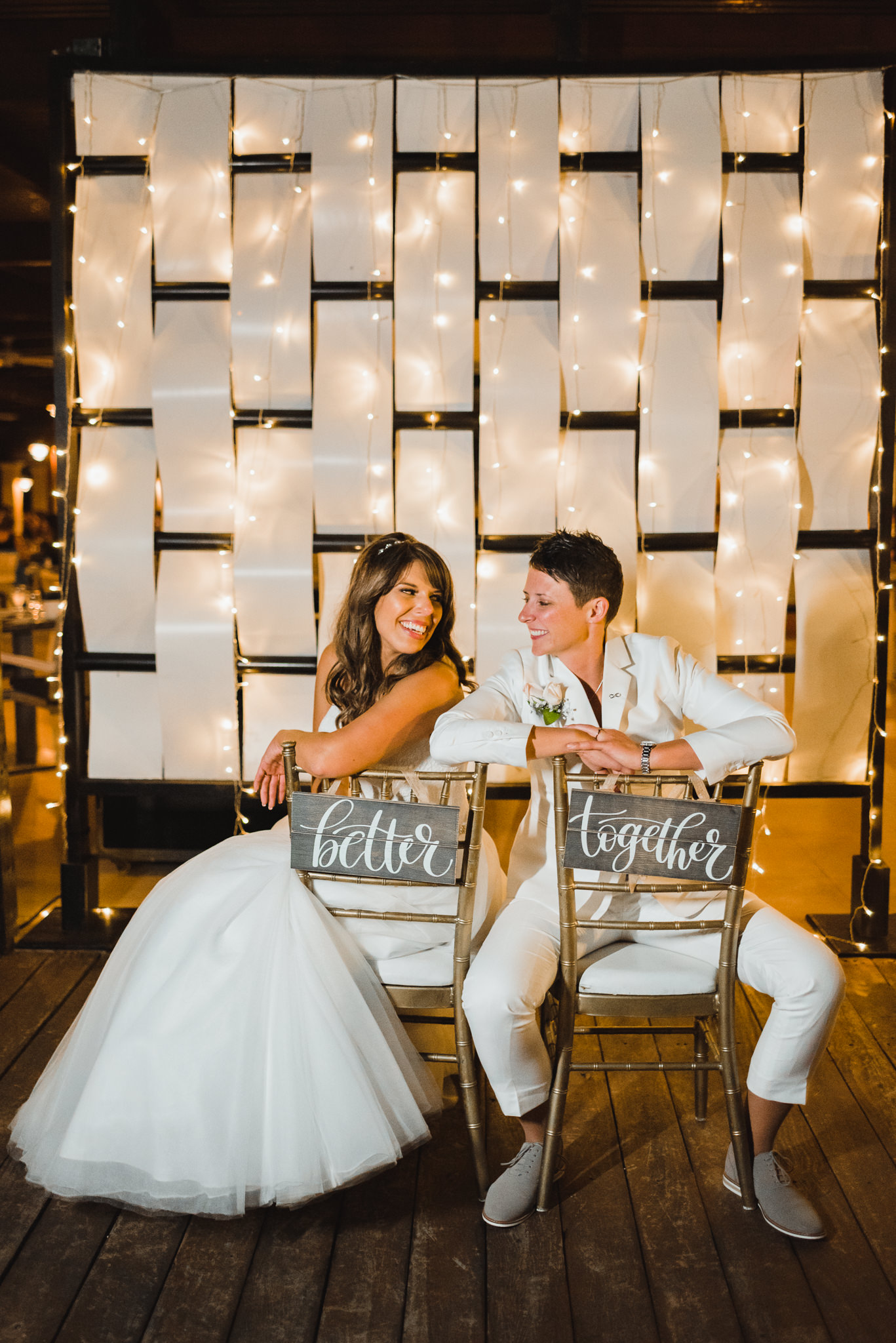 brides posing on chairs that read "better together" during wedding reception at Now Sapphire Resort in Mexico