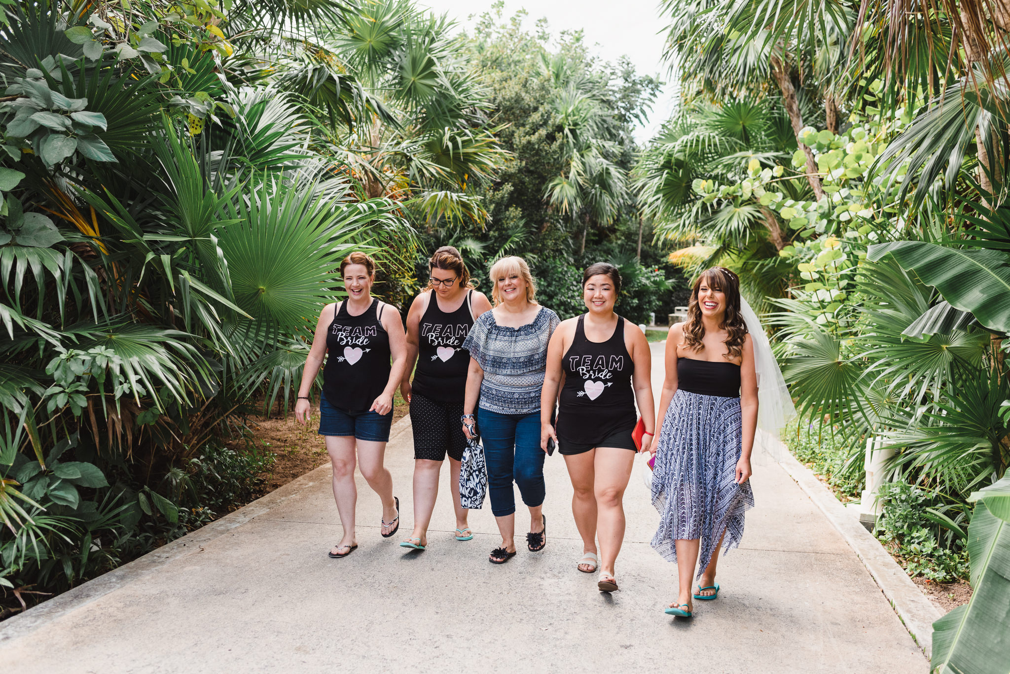 bride and wedding party strolling through lush gardens at Now Sapphire Resort in Mexico 