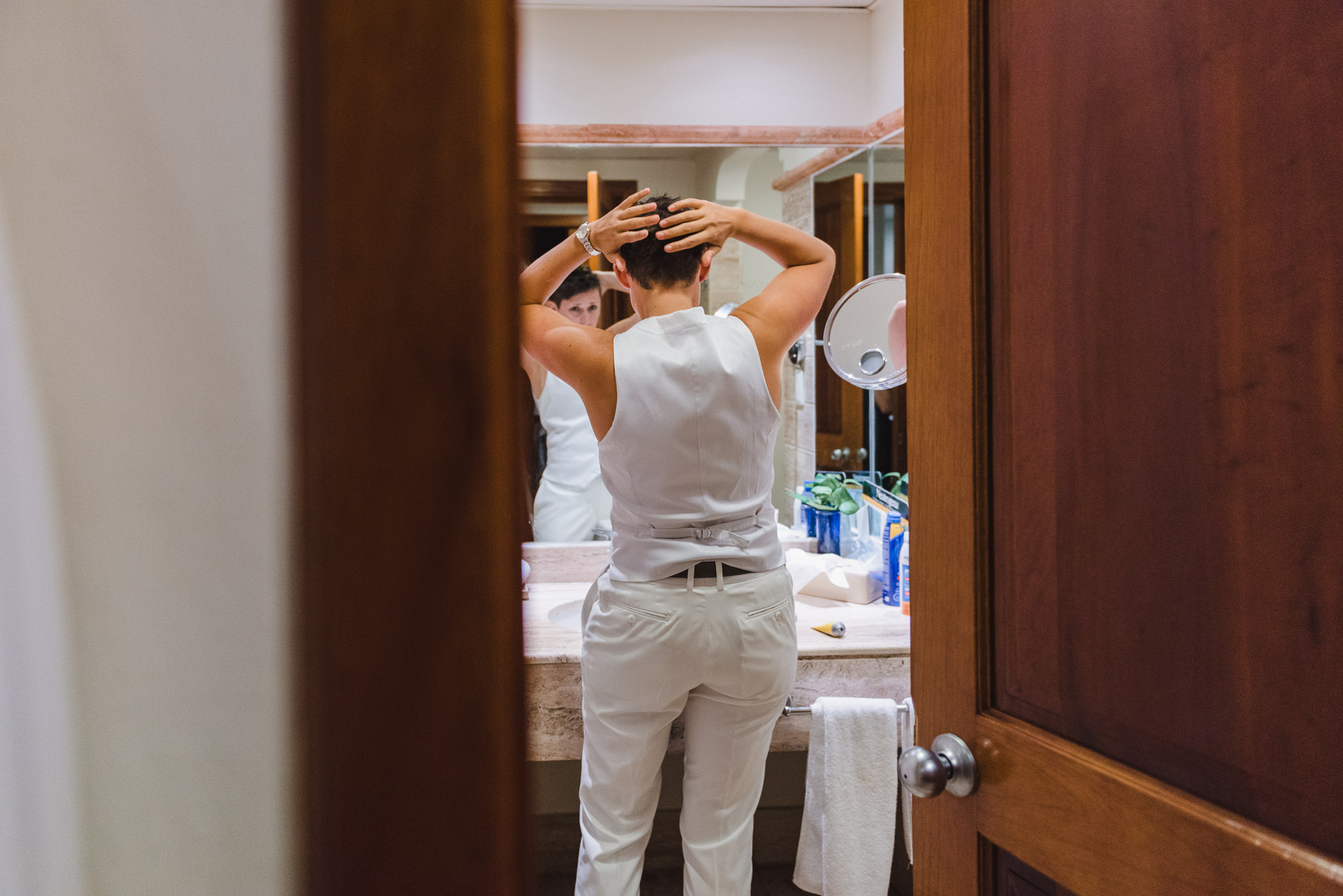 bride in the bathroom doing her hair before her destination wedding at Now Sapphire Resort in Mexico 