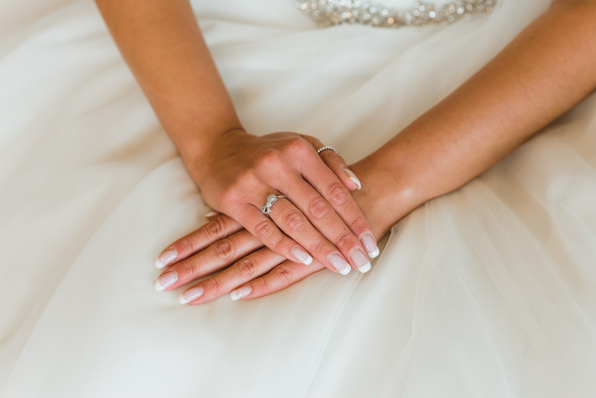 bride with her hands crossed over each other on her white wedding dress before wedding at Now Sapphire Resort in Mexico