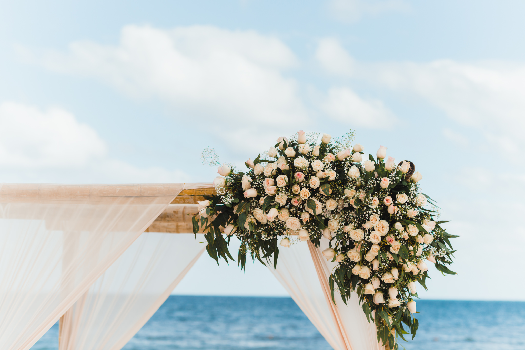 pink floral bouquet on top of wedding alter set up on beach in front of the ocean at the Now Sapphire Resort in Mexico how to be really relaxed during your wedding 