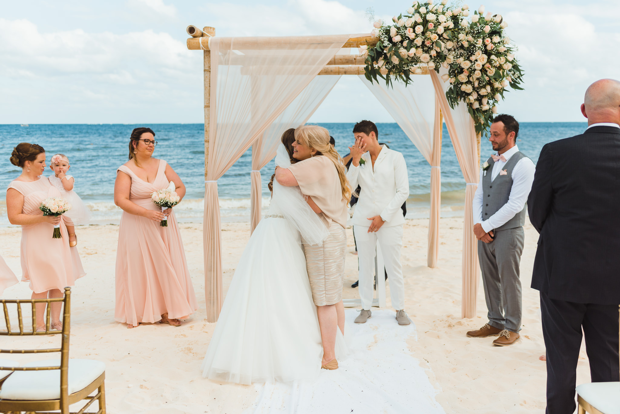 bride hugging mother at the wedding alter at a beach ceremony at Now Sapphire Resort in Mexico