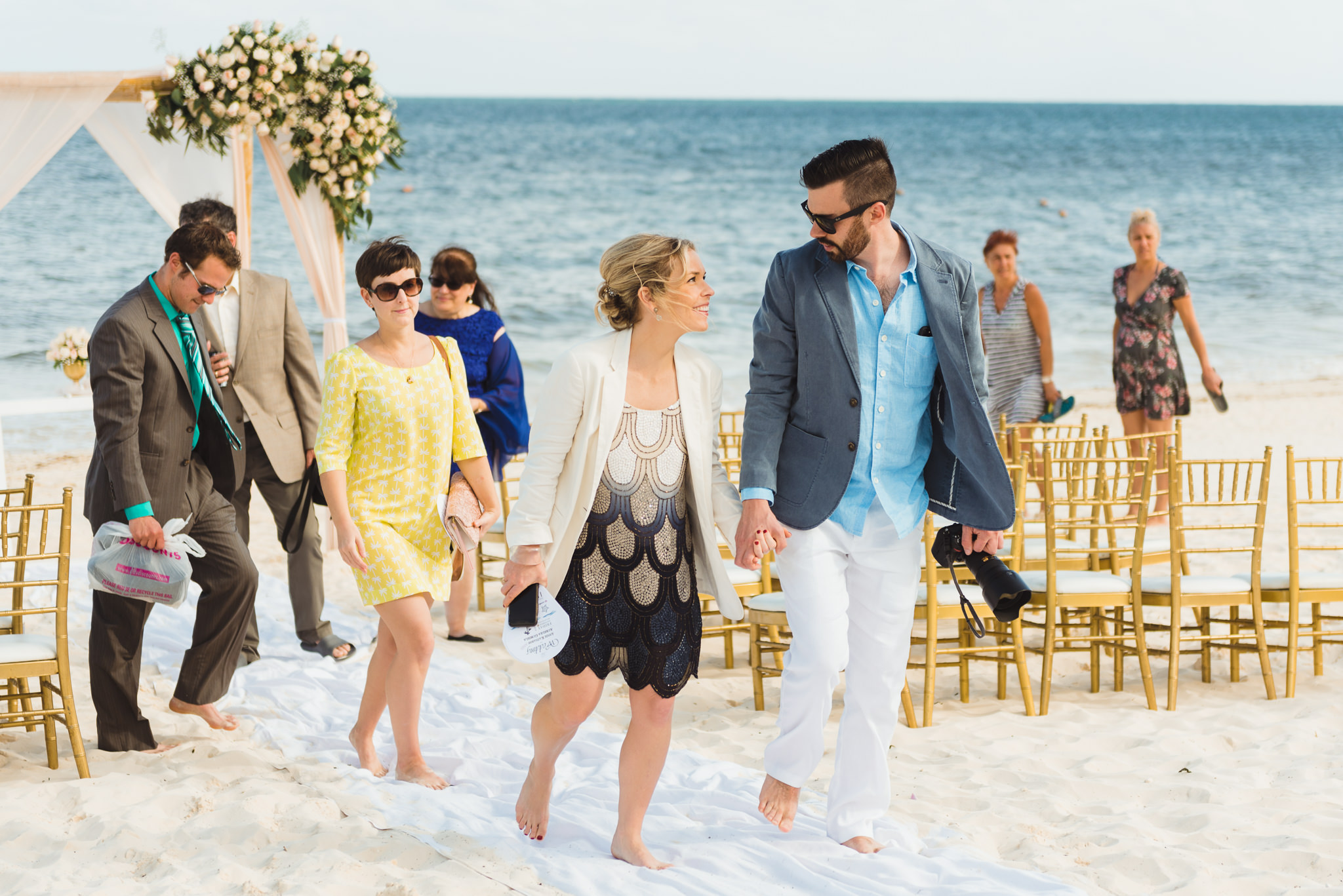 wedding guests exit beach ceremony in front of ocean at Now Sapphire Resort in Mexico
