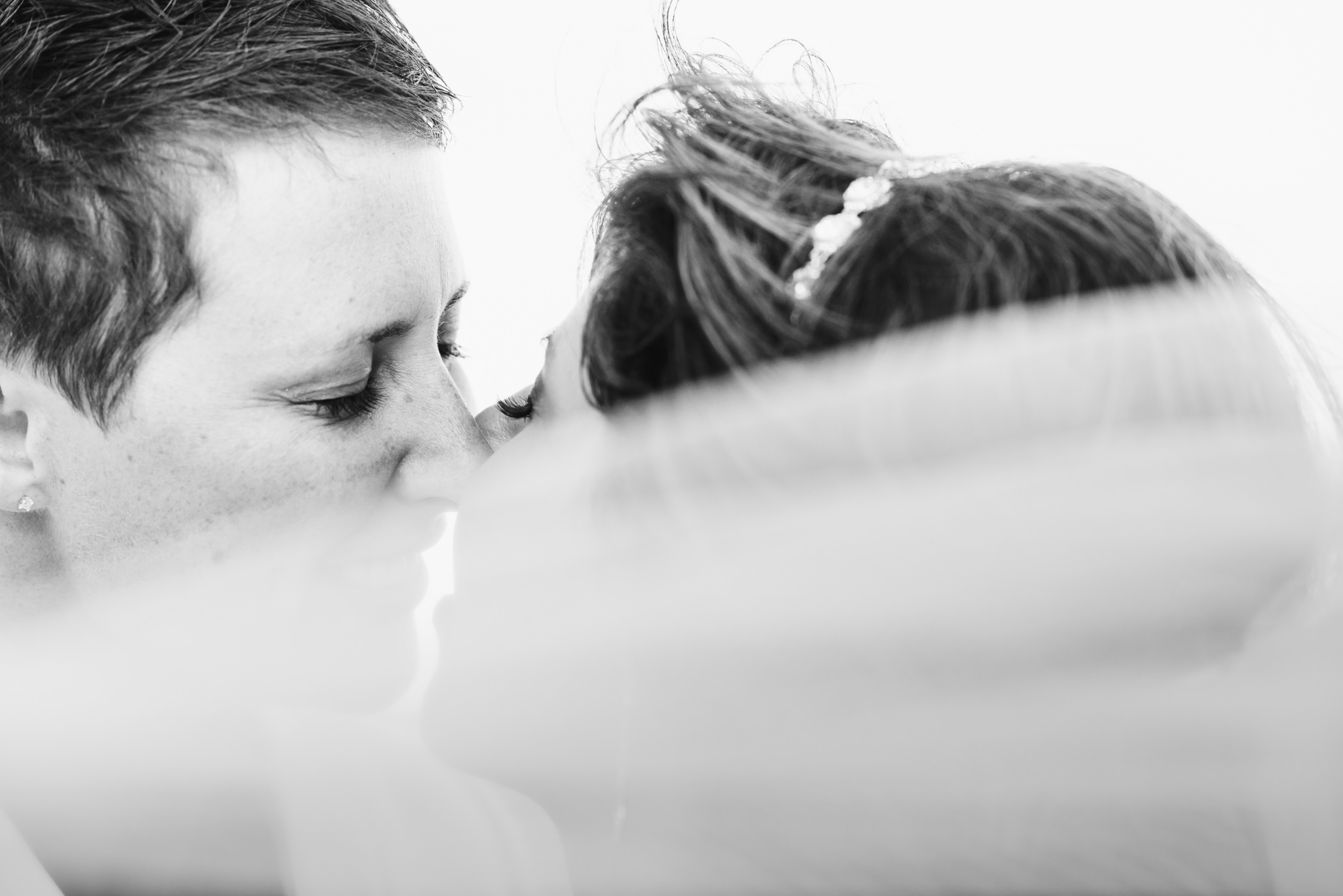 brides kissing on the beach after ceremony at the Now Sapphire Resort in Mexico