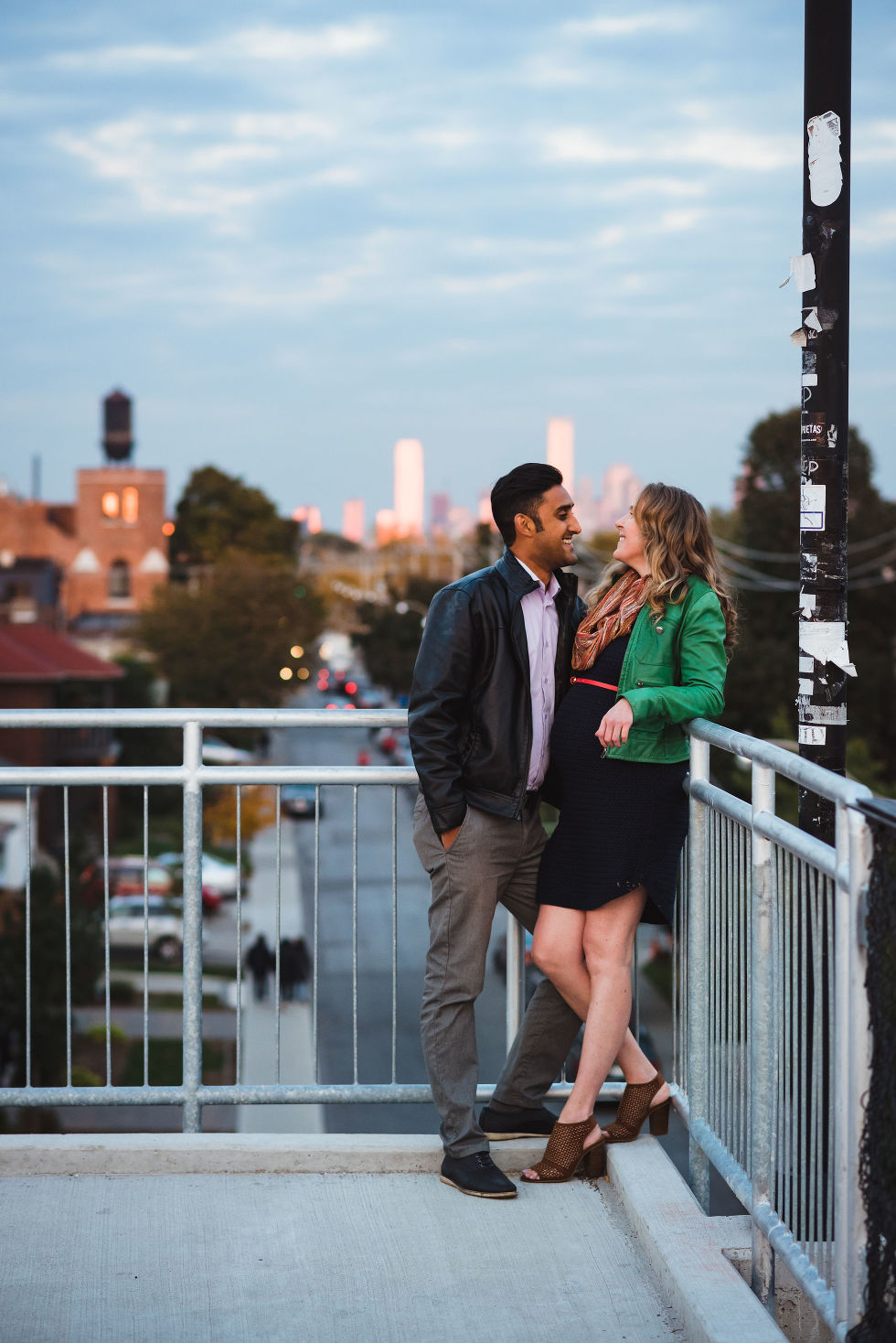 man and woman posing for maternity shots in the Junction neighbourhood of Toronto