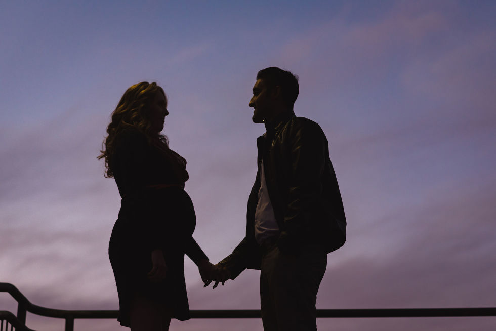 silhouette of a pregnant couple at dusk holding hands, Junction maternity photos 