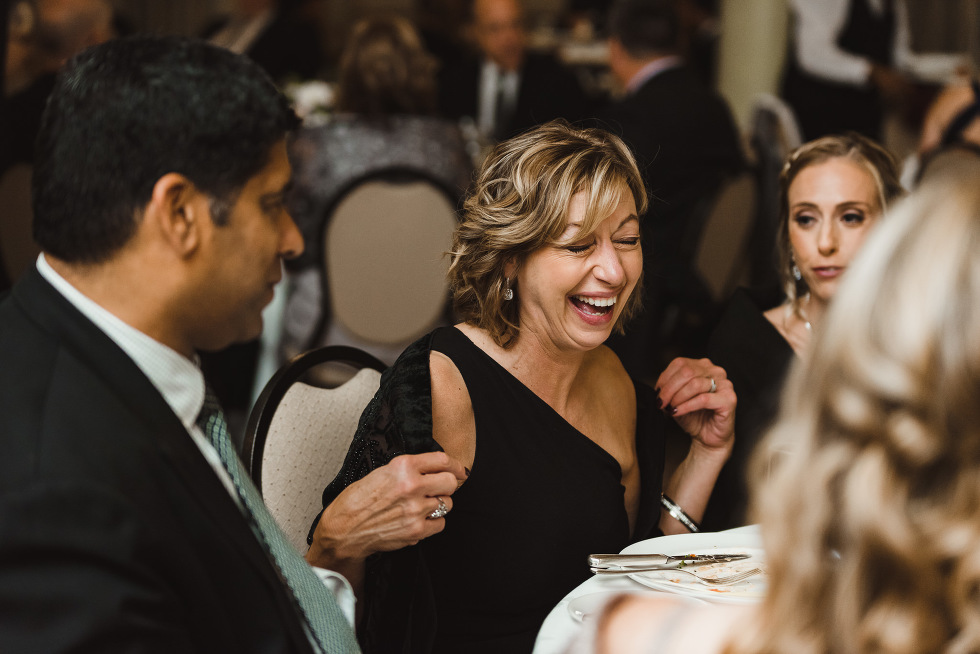 wedding guest laughing at her table with other guests during reception at the iconic University Club downtown Toronto wedding venue 