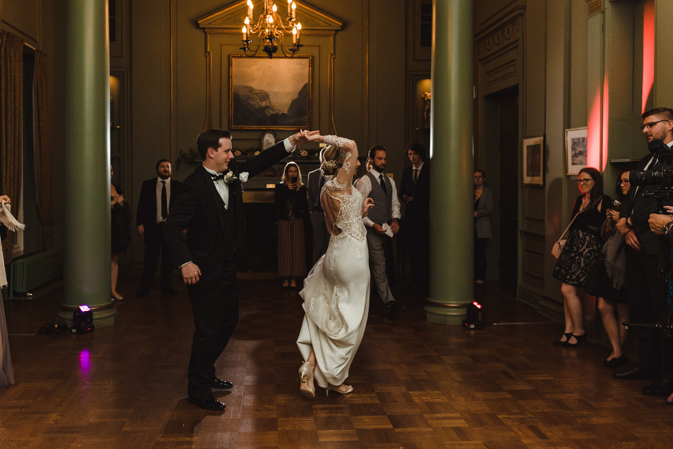 bride being twirled by groom on the dance floor as they share their first dance at the iconic University Club in downtown Toronto