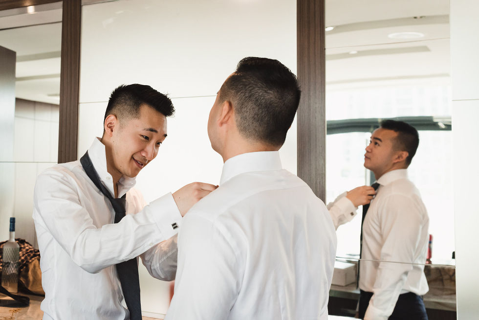 best man helping the groom put on his tie before his wedding at Fantasy Farms in Toronto Ontario