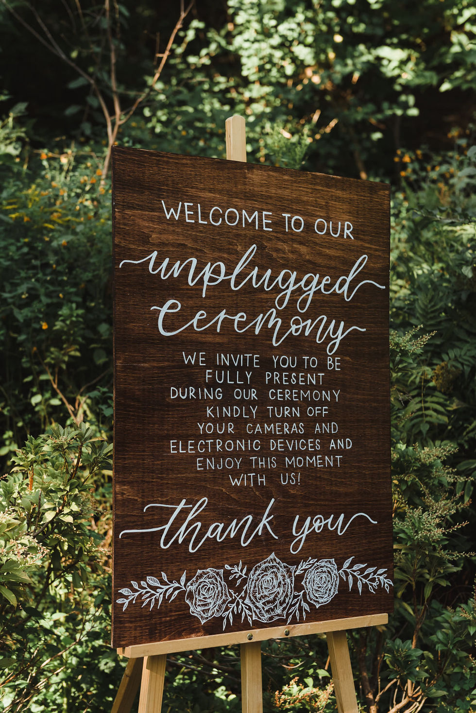 hand calligraphy unplugged ceremony wooden sign in front of a forest at Fantasy Farms in Toronto Ontario