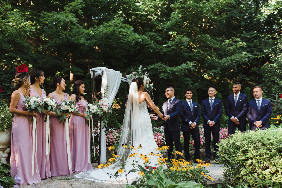 bridesmaid and groomsmen standing in front of garden at Fantasy Farms in Toronto Ontario