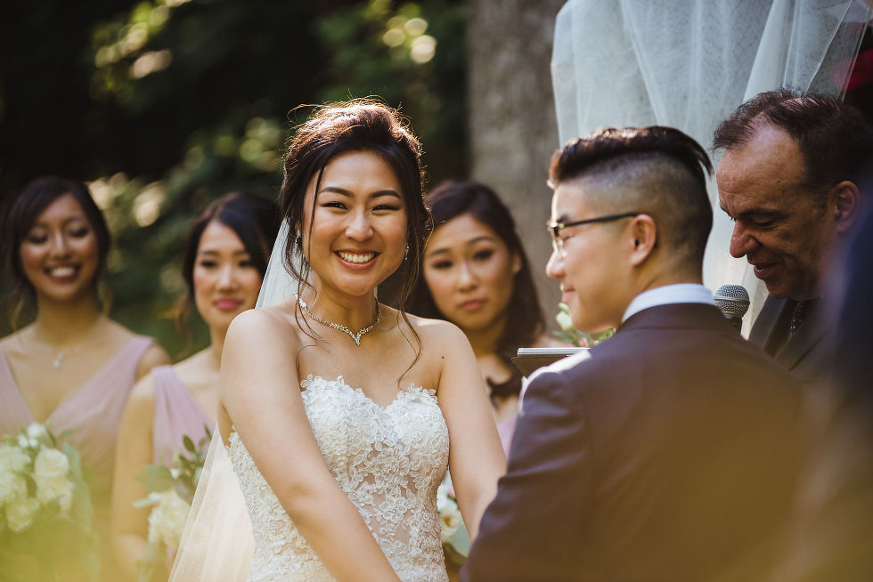 bride smiling holding grooms hands at Fantasy Farms in Toronto Ontario