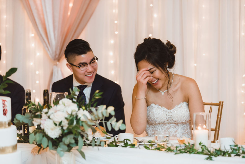 bride and groom laughing with twinkle lights and white curtains in background at Fantasy Farms in Toronto Ontario