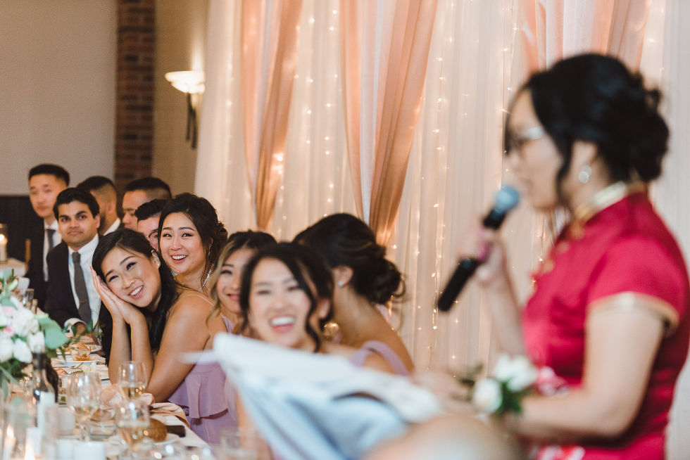 bridal party laughing and crying at wedding speeches at Fantasy Farms in Toronto Ontario