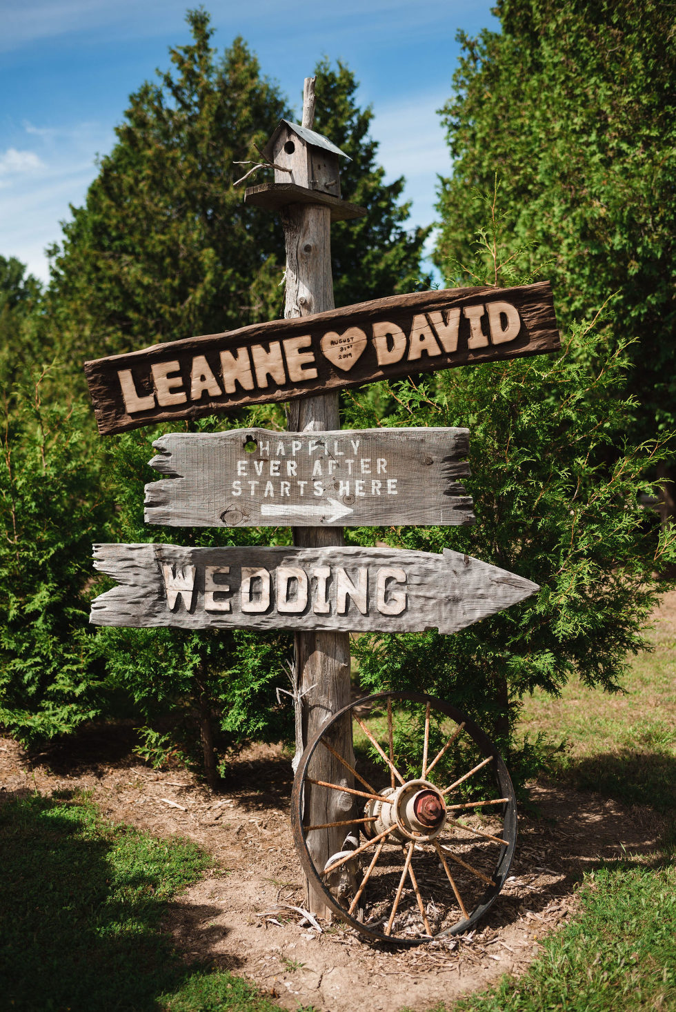 wood post with bird house on top and signs pointing out where the wedding guests go how to make your wedding day special to you