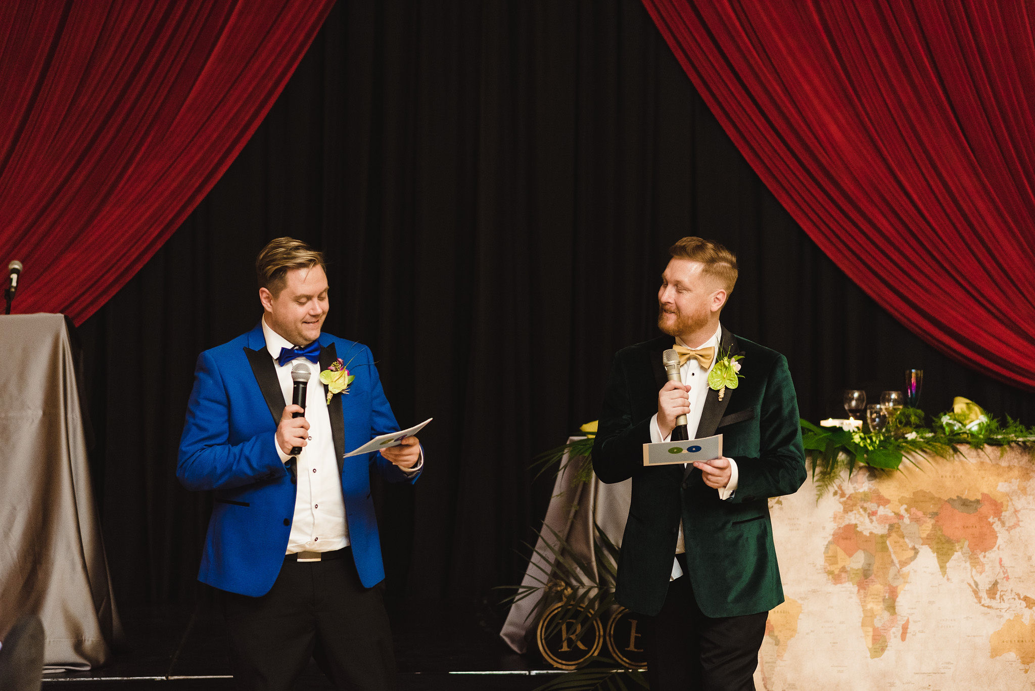 grooms reading their wedding speeches into their microphones during a fun wedding reception at the Hilton Fallsview in Niagara Falls