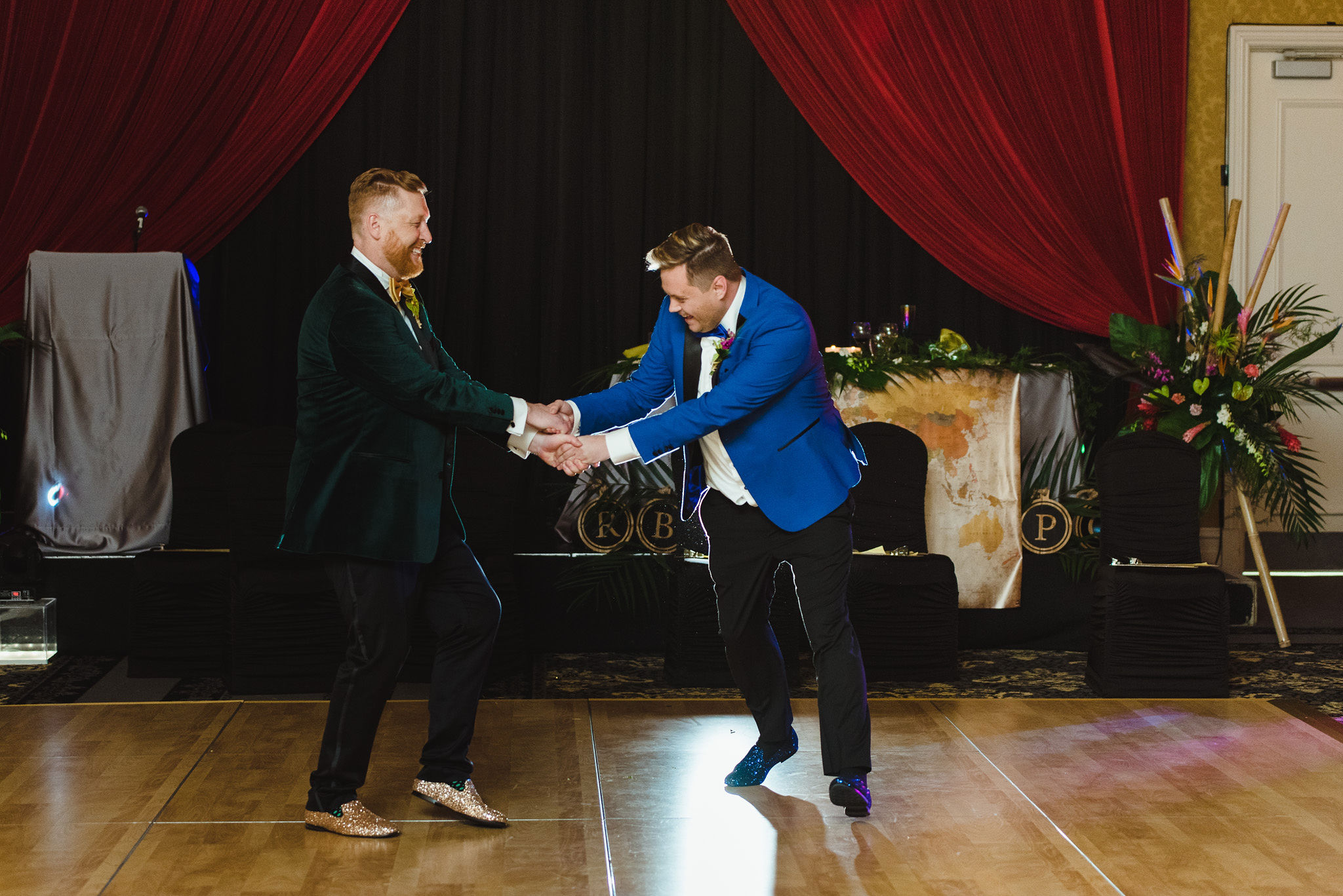 grooms holding hands and dancing during their fun wedding reception at the Hilton Fallsview in Niagara Falls