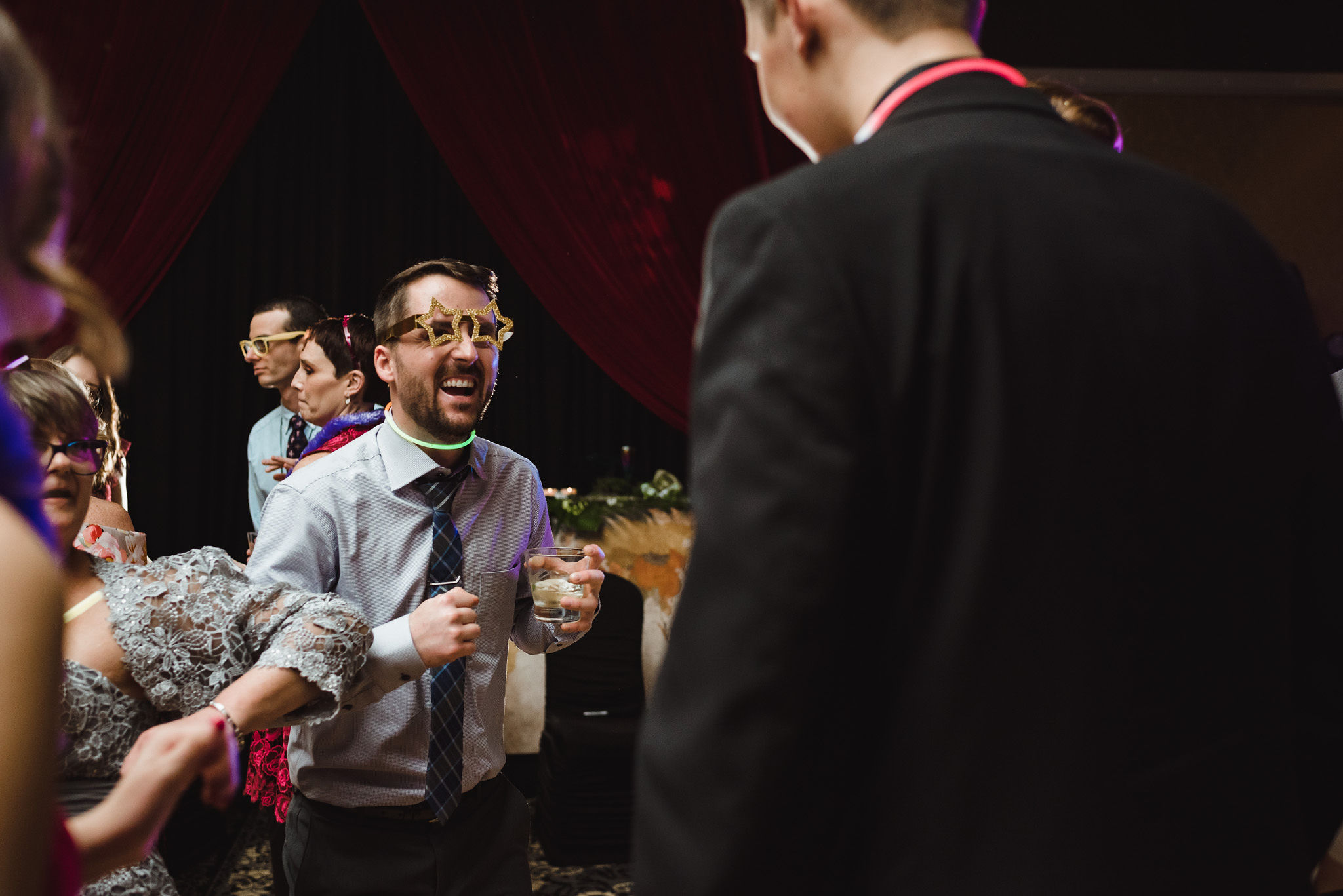 wedding guests wearing wacky glasses, while dancing and laughing during a fun wedding at the Hilton Fallsview in Niagara Falls
