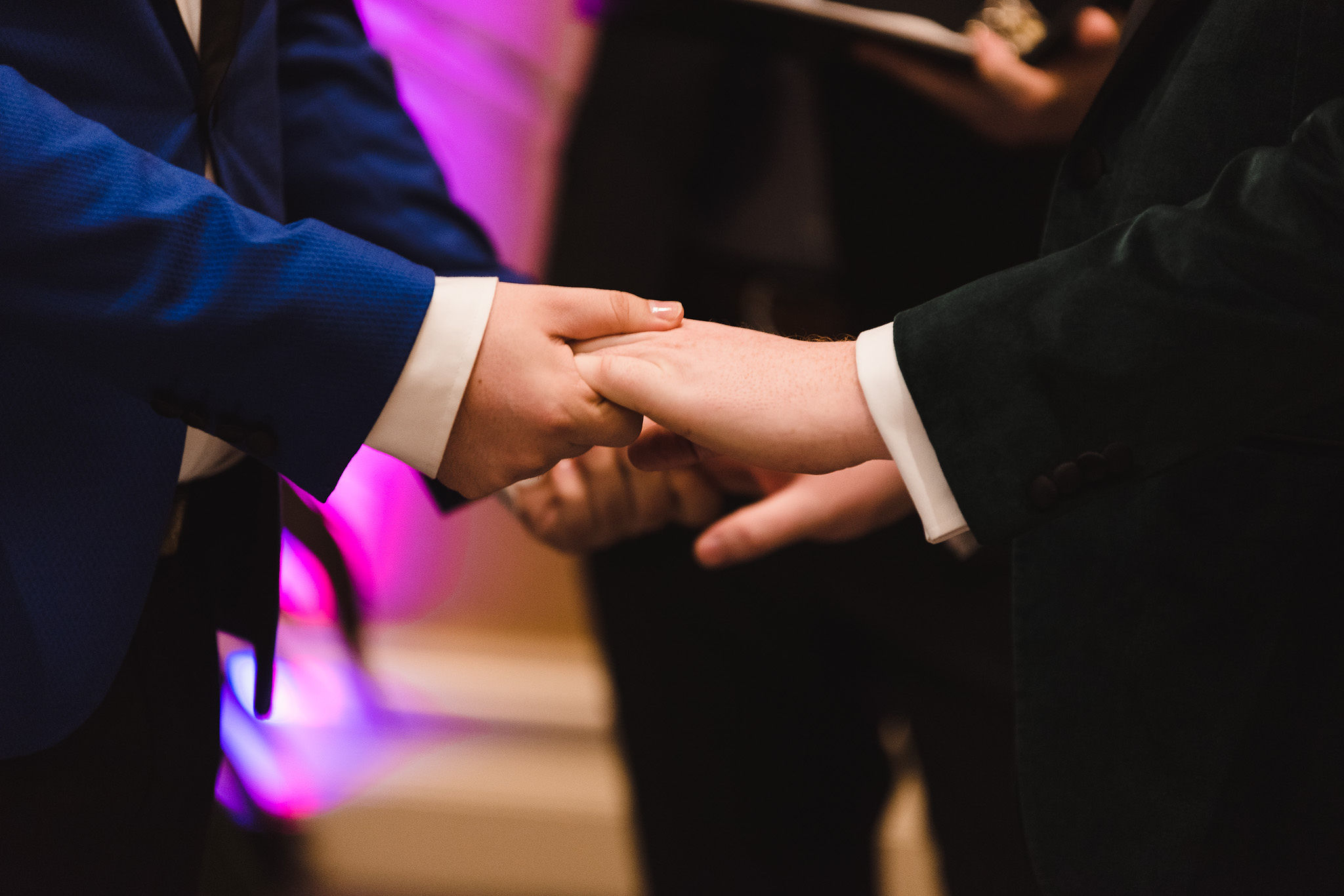 grooms holding hands during wedding ceremony at the Hilton Fallsview in Niagara Falls