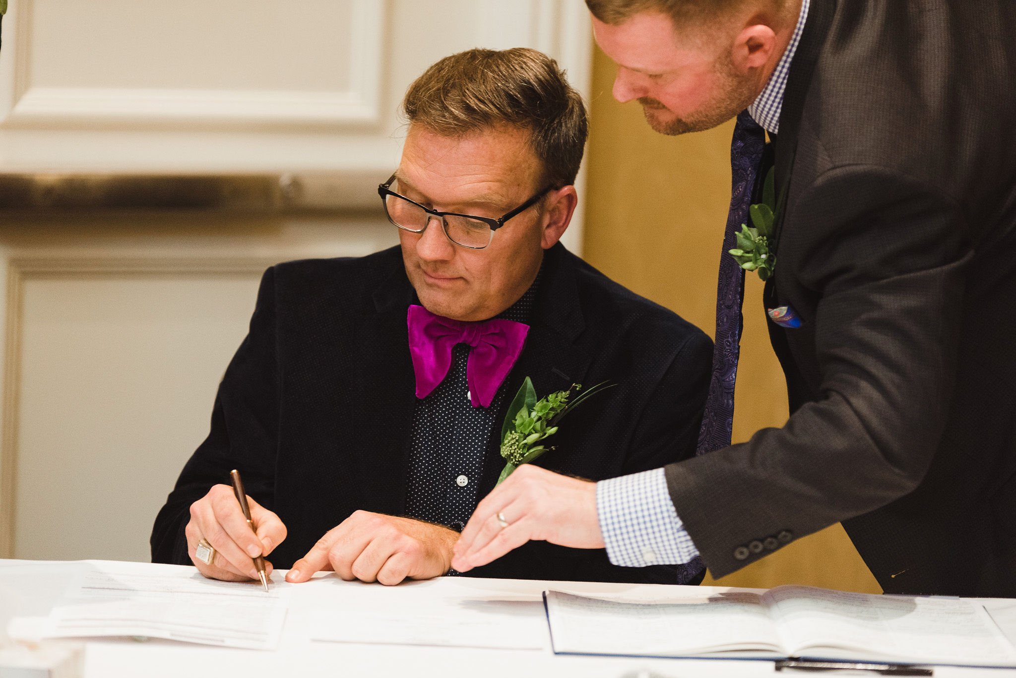 man pointing out where the witness signs the marriage certificate during ceremony at the Hilton Fallsview in Niagara Falls