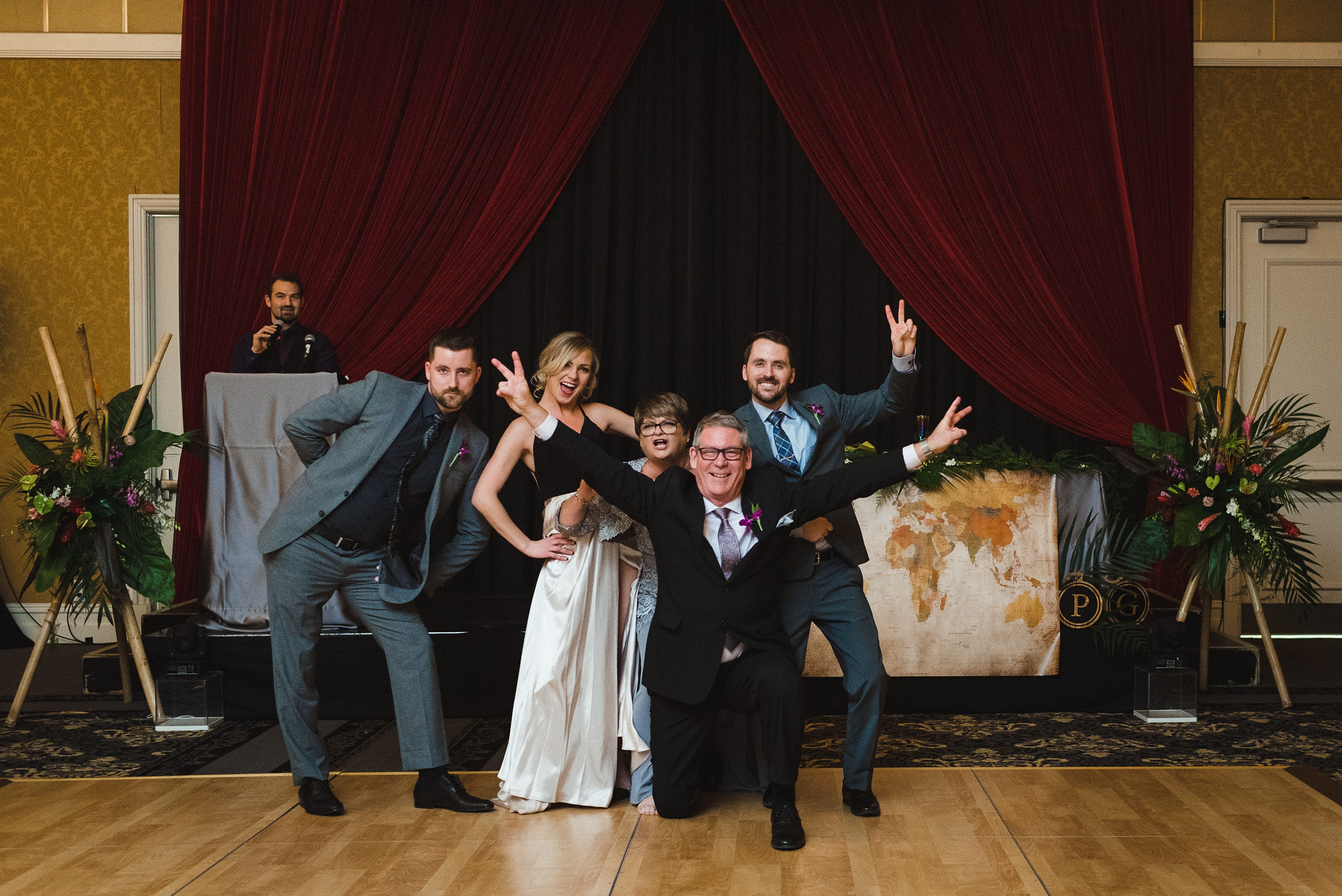 wedding guests posing together on the dance floor and holding up peace signs with their hands during wedding reception at the Hilton Fallsview in Niagara Falls