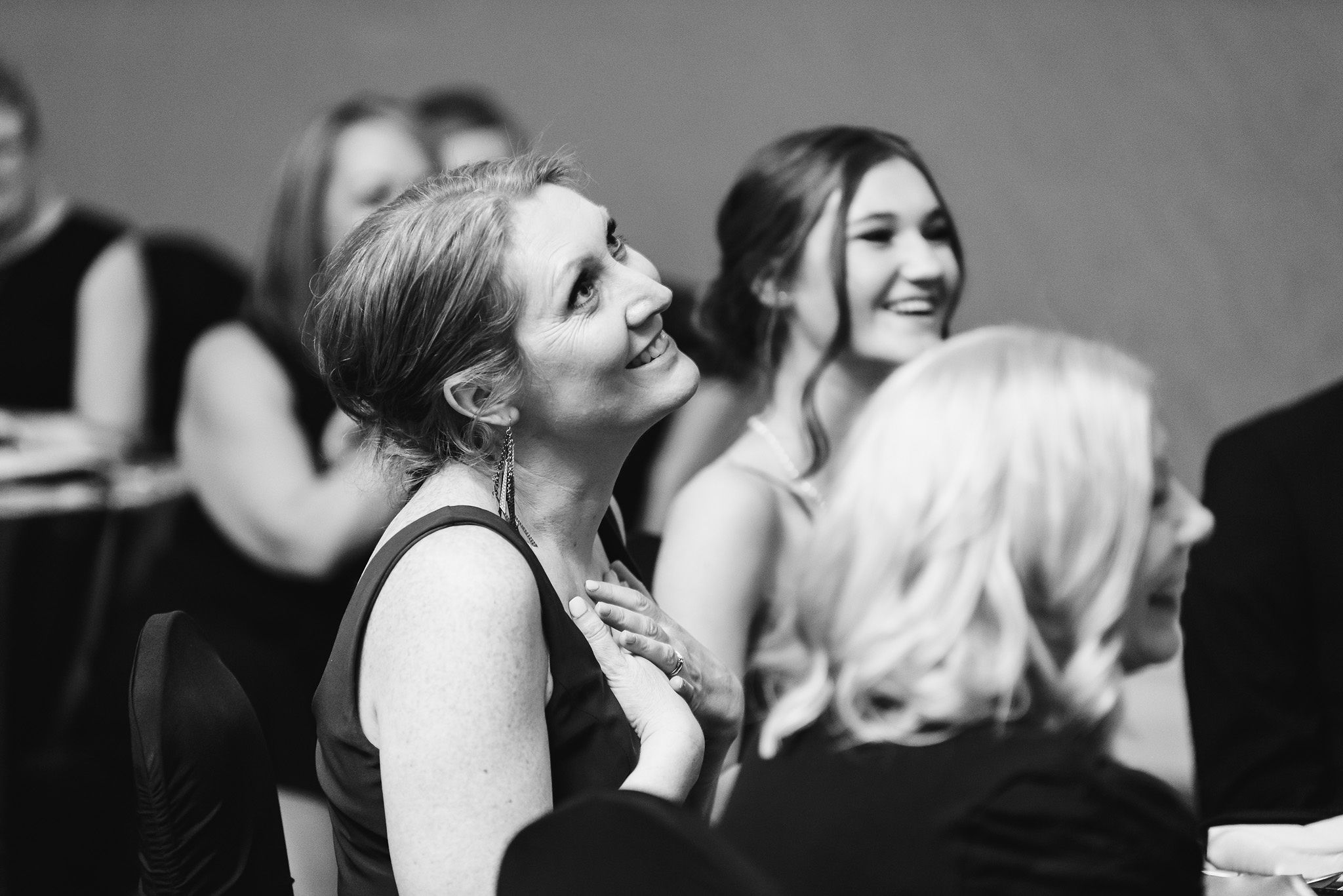 wedding guest with her hands over her chest and smiling during wedding speeches at the Hilton Fallsview in Niagara Falls