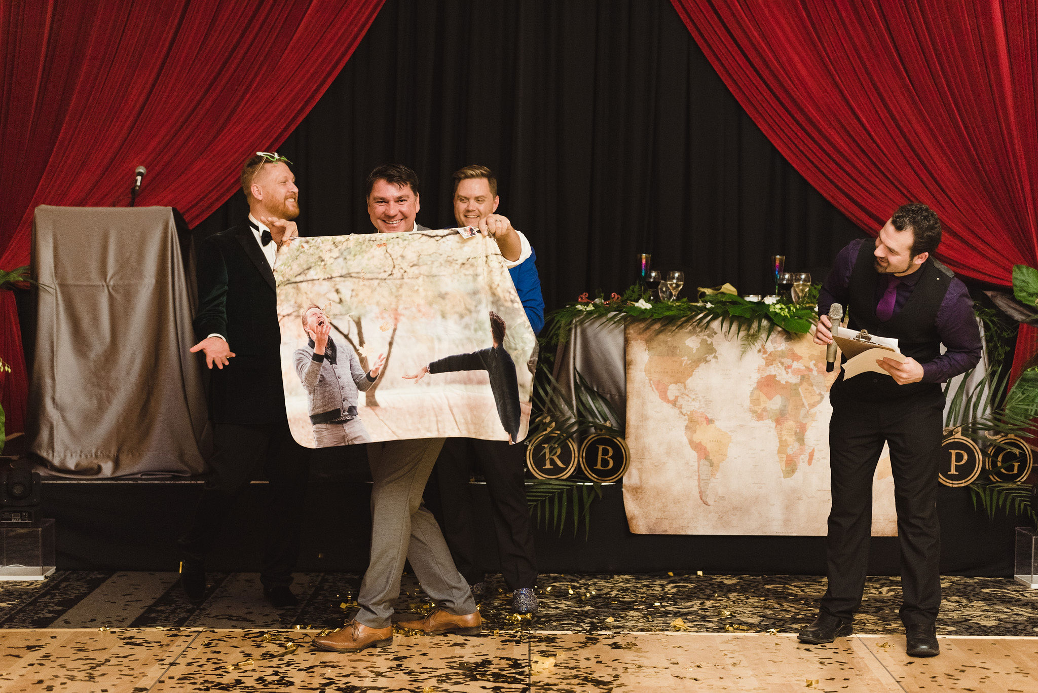 wedding guest holding up large picture of the grooms during the fun wedding reception at the Hilton Fallsview in Niagara Falls