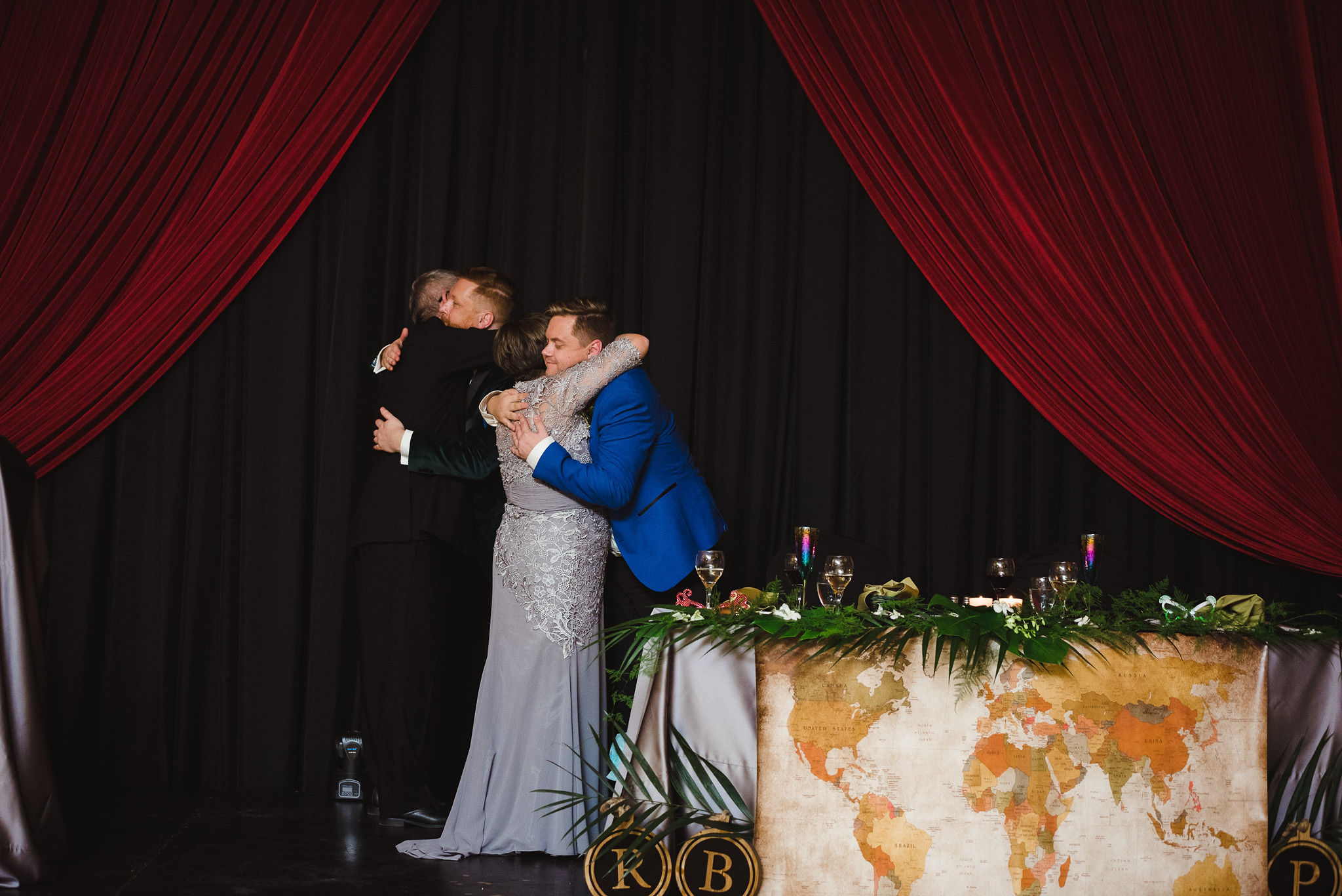 grooms hugging parents during fun wedding reception at the Hilton Fallsview in Niagara Falls