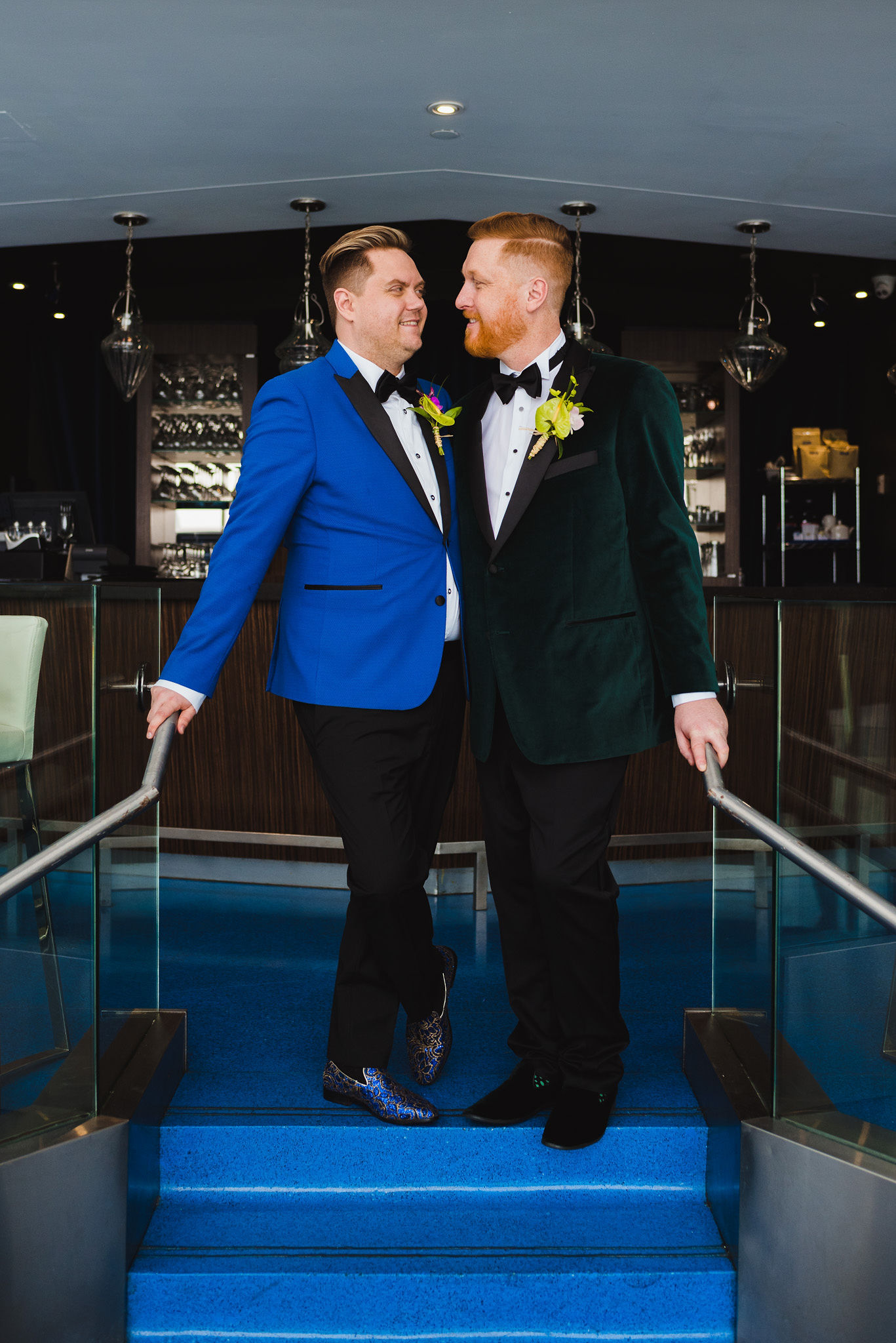grooms facing each other while standing in front of the bar at the Hilton hotel in Niagara Falls before their wedding