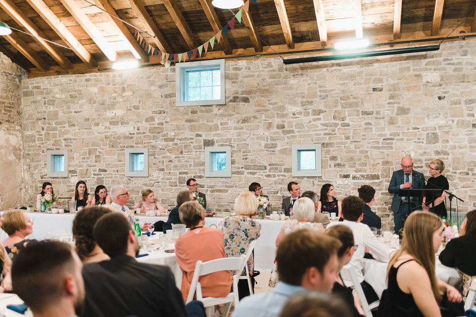bride, groom, wedding party, and wedding guests all looking towards the podium and listening to speeches during a charming southern style wedding at Ruthven National Historic Site 