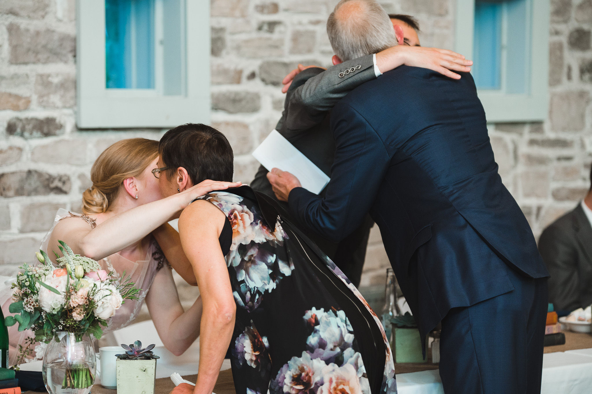 bride and groom getting up from their table to hug grooms parents after their speech during their charming southern style wedding at Ruthven National Historic Site near Hamilton