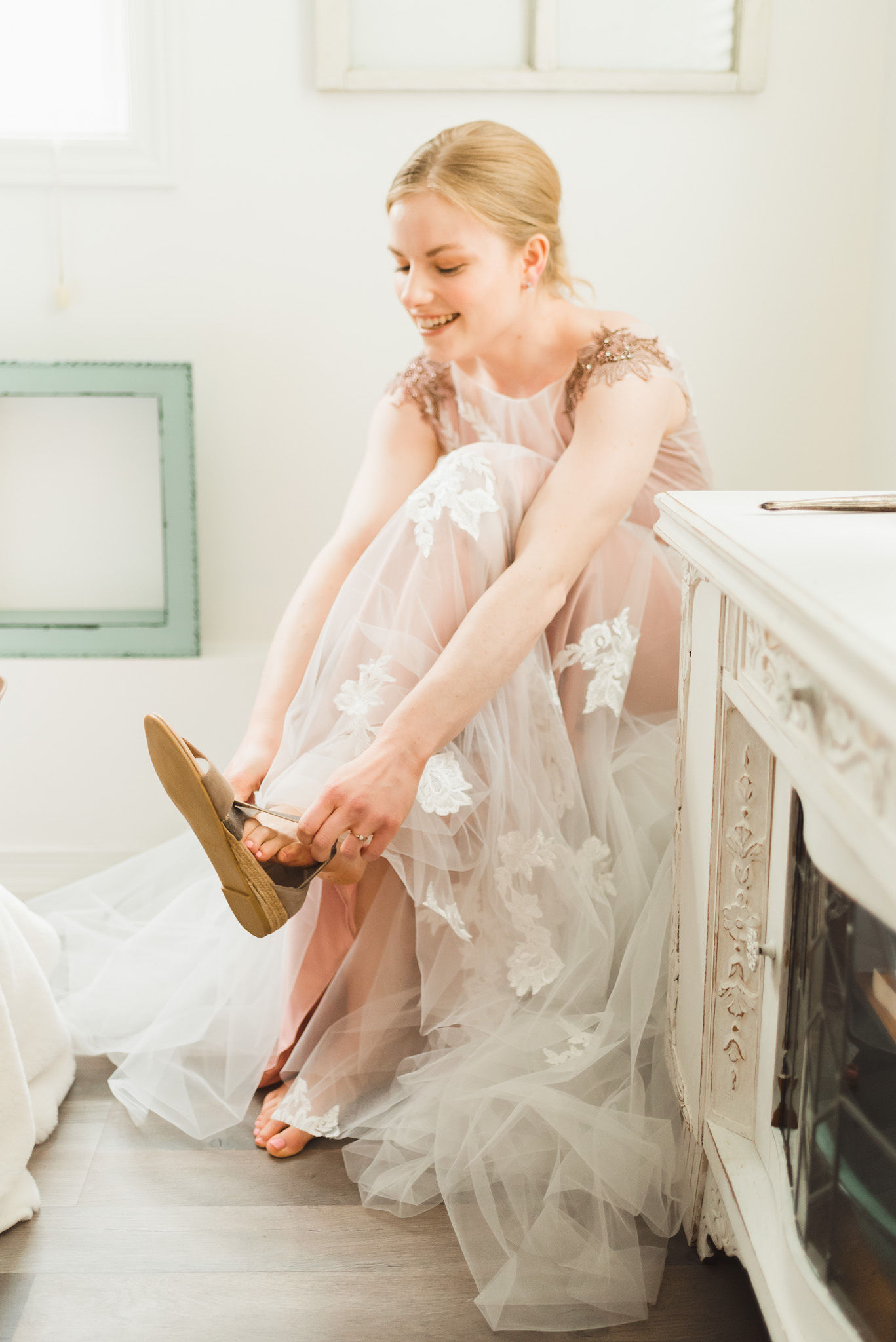 bride in her wedding dress seated while putting on her shoes before her charming southern style wedding at Ruthven Park National Historic Site