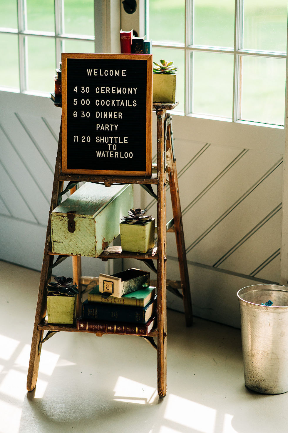 bookshelf with books and a welcome sign with a wedding day itinerary for the guests at Ruthven Park National Historic Site