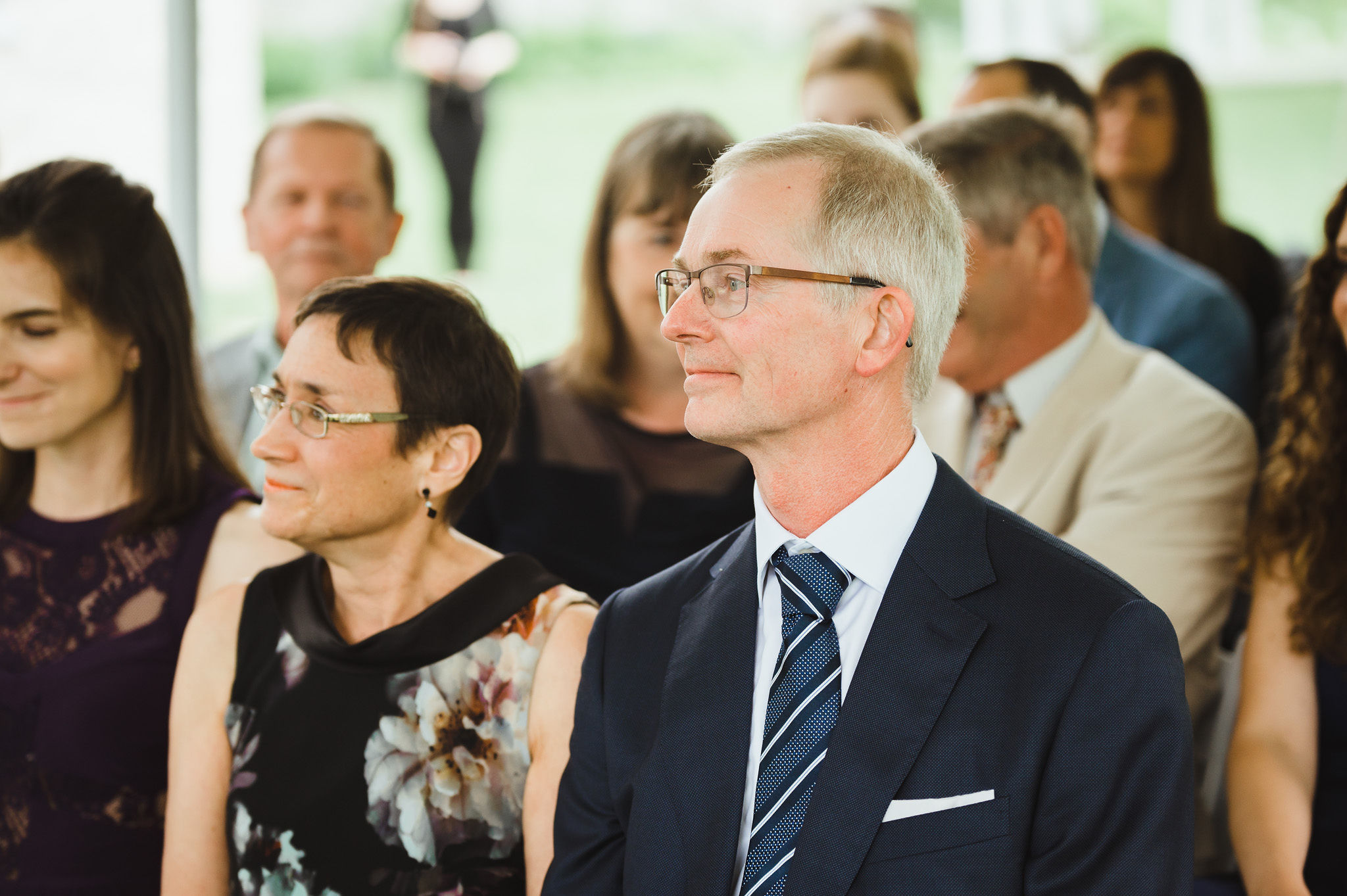 parents of the bride seated and watching their daughter get married at Ruthven Park National Historic Site near Hamilton Ontario