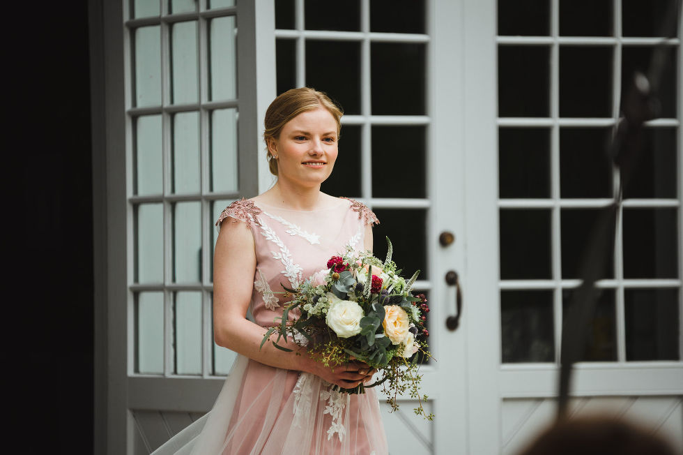 bride holding floral bouquet beginning her walk down the aisle during her charming southern style wedding at ruthven national historic site