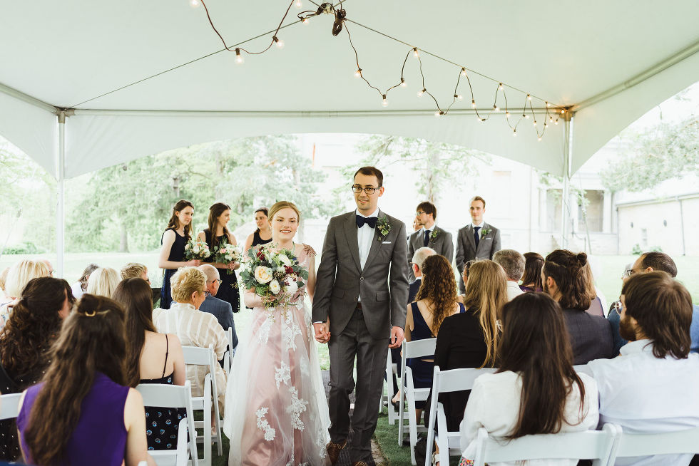 bride and groom holding hands as they exit their charming southern style ceremony at Ruthven National Historic Site near Hamilton