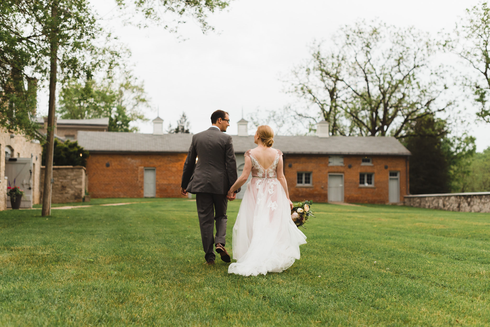 bride and groom stroll hand in hand across the lawns of the Ruthven National Historic Site during their charming southern style wedding