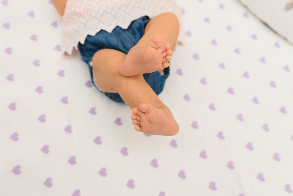 A newborn in crib lifting their feet in the air Toronto newborn photography